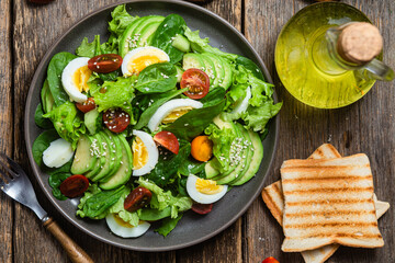 Salad with spinach, avocado, tomatoes in a plate. Vegetarian salad