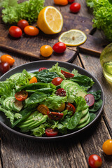 Salad with spinach, avocado, tomatoes in a plate. Vegetarian salad