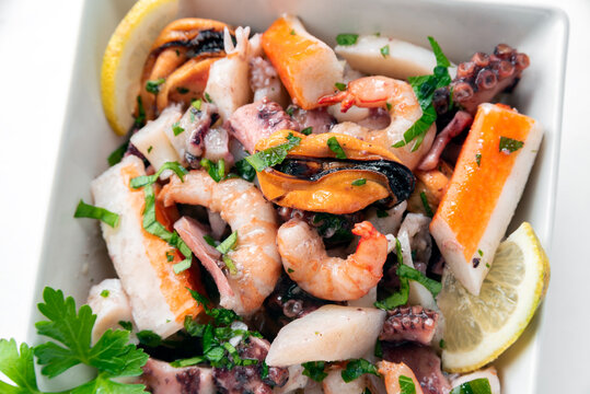 Insalata di frutti di mare freschi: surimi, gamberetti, cozze, vongole, polpi e calamari, cibo italiano 