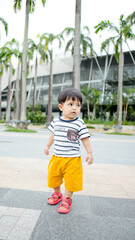 Fototapeta premium A Malay boy wearing stripes clothes and yellow pants at the bay