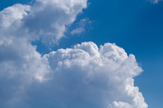 Blue sky with white puffy fluffy clouds, horizontal natural background