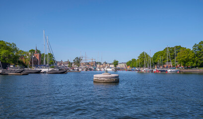 Stone bollard in a bay with sailing boats, a sunny summer day in Stockholm