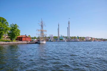 View over islands in the bay Strömmen at the Vasa depth, old sailing ship and the Tivoli towers on the island Djurgården, a sunny summer day in Stockholm 