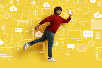 Smiling man with phone running over diverse digital world icons