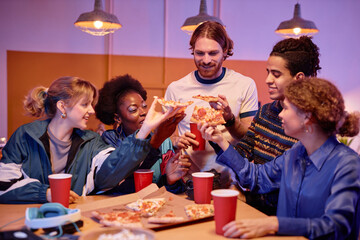 Diverse group of young people eating pizza at house party 80s style