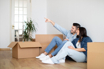 Design Ideas. Couple Sitting On Floor Among Cardboard Boxes In New Flat