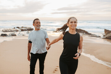 Positive mature european woman holding man hand, enjoy workout together in morning
