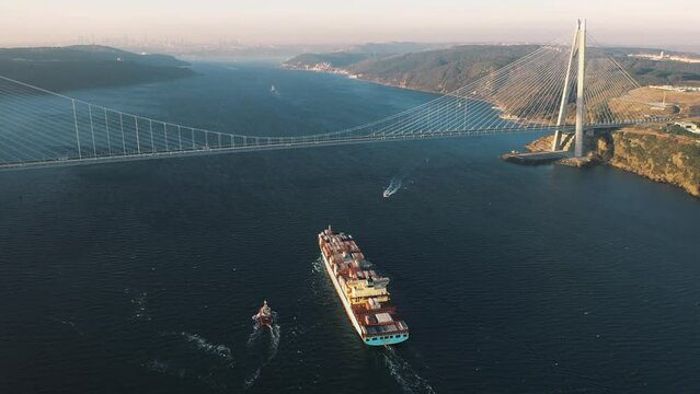 A large container ship heading towards the Istanbul. Aerial Bosphorus Sea. Cargo vessel sails under the Yavuz Sultan Selim Bridge in the early morning

