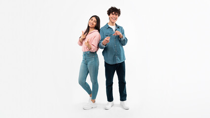 Cheerful Couple Posing Pointing Fingers At Camera Over White Background