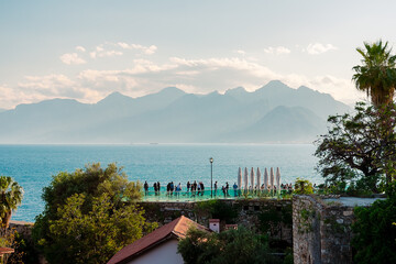View of the mountains, the sea and the viewing platform in the Turkish city of Antalya. Evening in...