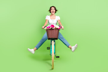 Full length photo of excited funky woman dressed white top riding bicycle isolated green color...