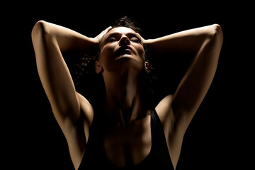 Portrait of a woman in the shadow, hold her head , closed eyes on a black background