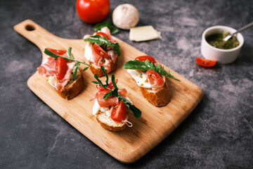 Bruschetta with prosciutto, pesto, mozzarella and tomatoes. Food, restaurant and event concept.