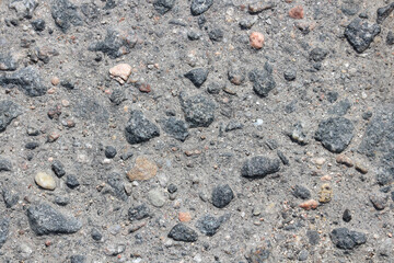 Texture of treaded old asphalt. Stones in the destroyed sidewalk.
