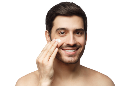 Young man spreading face cream with fingers as part of morning selfcare routine