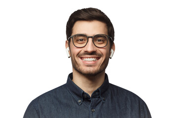 Obraz premium Close-up headshot of young smiling man wearing blue denim shirt, listeting to his favorite music track with earphones