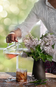 A woman pouring lilac syrup to drink 