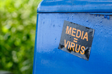 Sticker on a public trash can with text media = virus. Pointing out that the media is spreading...