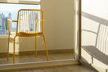 Yellow Metal Chair on Balcony with Serene View, Embracing Summer Bliss.
