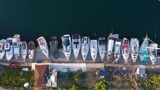 Aerial top down view of Marina dock or basin with moorings and supplies for yachts and small boats, used exclusively by non-industrial pleasure craft such as sloops and cabin cruisers. Kucukyali Shore