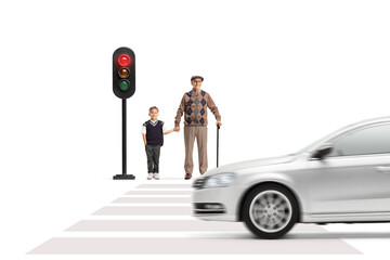Elderly man and a schoolboy waiting to cross street at traffic lights