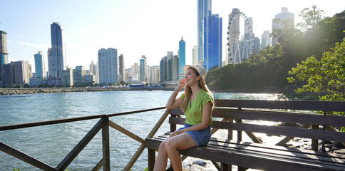 Fashion girl enjoying Balneario Camboriu city architecture. Travel in Brazil. Banner with copy...