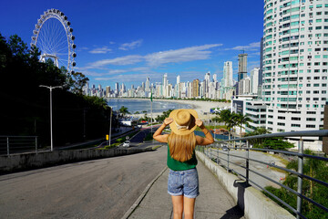 Holidays in Brazil. Back view of young woman enjoying Balneario Camboriu city skyline with Ferris...