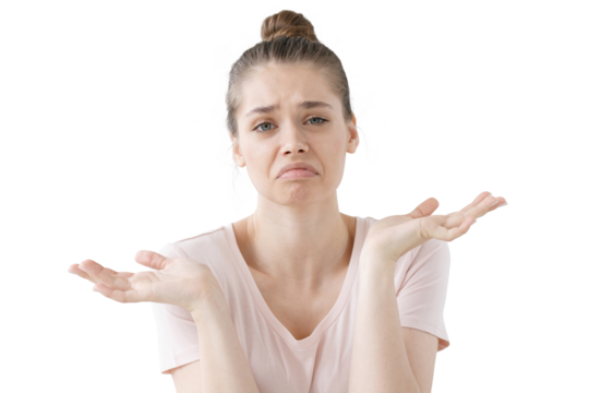 Closeup of emotional young woman isolated on grey background being at a loss, showing helpless gesture with arm and hands, mouth curved as if she does not know what to do with current situation.
