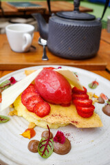 Fototapeta na wymiar A white chocolate dessert with strawberry ice cream and strawberries.
