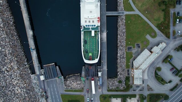 Top down aerial view on industrial port cargo ships and ferries. Cars and vehicles load up on transport ferry. Naval and sea logistics and transportation