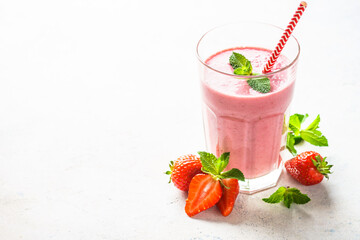 Strawberry smoothie or milkshake at white table.