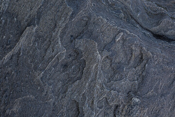 Close-up of a unique and beautiful rock surface, front view. Abstract full frame natural textured dark background.