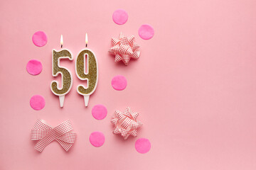 Number 59 on pastel pink background with festive decor. Happy birthday candles. The concept of...
