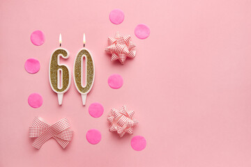 Number 60 on pastel pink background with festive decor. Happy birthday candles. The concept of celebrating a birthday, anniversary, important date, holiday. Copy space. Banner