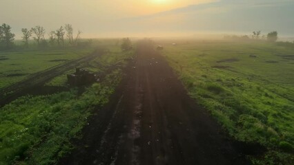 Flight over the road after hostilities. Ukrainian military vehicles, SUVs, and tanks were blown up and shot up all around. The field after the mortar shelling and artillery of the Russian invaders.
