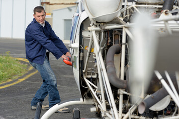 mechanic moving light aircraft at airfield