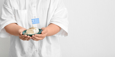 Person holding Greek cheese on light background