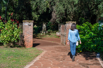 Fototapeta na wymiar Woman tourist walking alone in jeans and loose hair walking through the ruins of San Ignacio Mini.