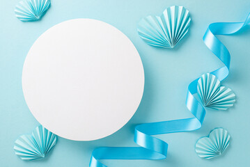 Top view photo of white empty circle with a pastel blue ribbon and origami paper hearts on an...