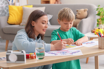 Obraz na płótnie Canvas Nanny with little boy drawing at home