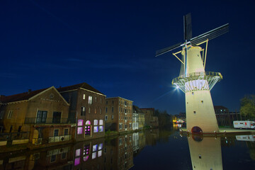 Fototapeta na wymiar The channel and the windmill at the night in Schiedam