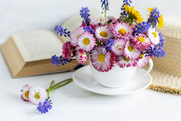 Fototapeta na wymiar Greeting card for Women's or Mother's Day, 8th of March. Beautiful spring or summer floral composition with daisy camomile flowers in a white cup for countryside table decor. Wooden background