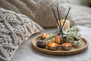 Home comfort, coziness, aromatherapy. Cozy interior with knitting, burning candles and aroma...
