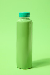 Bottle of fresh soda on green background