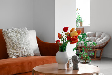 Vase with beautiful tulip flowers on coffee table in interior of living room