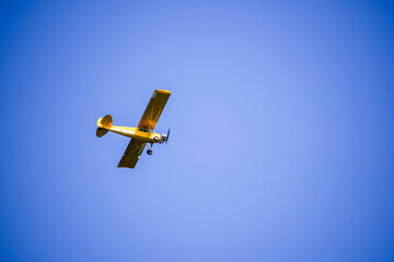 A yellow plane in the sky over the New Jersey shore 