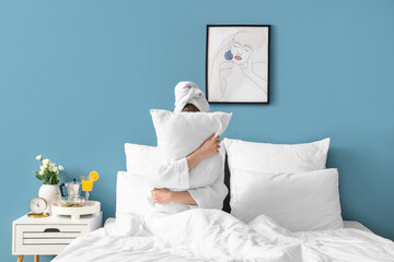 Morning of young woman hugging pillow in bedroom