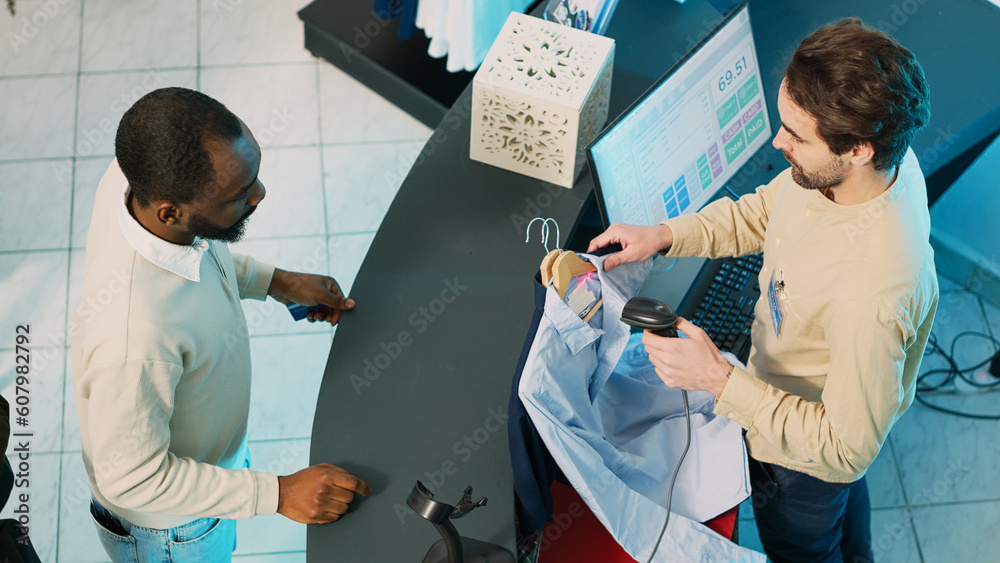 Wall mural african american man buying clothes at shop cash register, using card to make transaction on pos ter - Wall murals