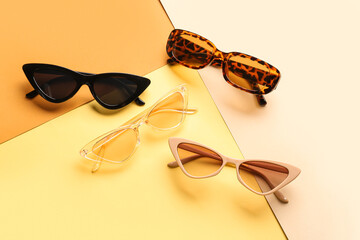 Stylish sunglasses on color background
