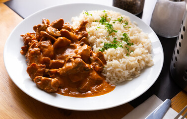 Traditional Czech Stroganoff pork tenderloin served with rice and greens..